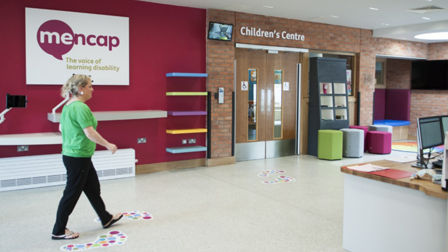 Woman walking through Mencap Centre reception