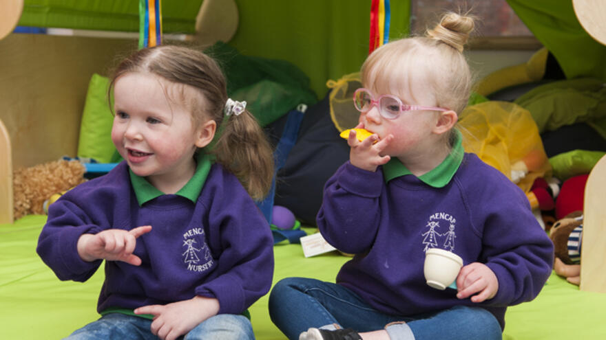 Two young children sat together playing