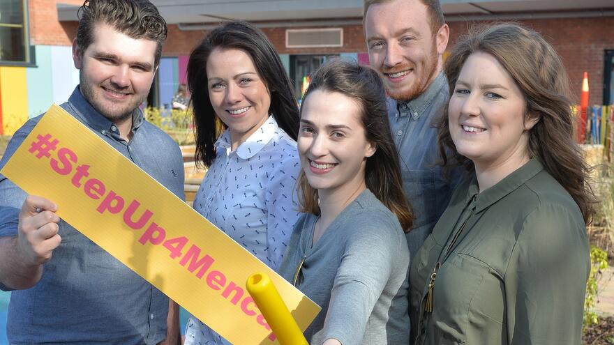 Group of people stood outside Mencap Centre in Belfast holding a #StepUp4Mencap banner