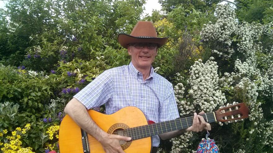 Man stood outside holding a guitar