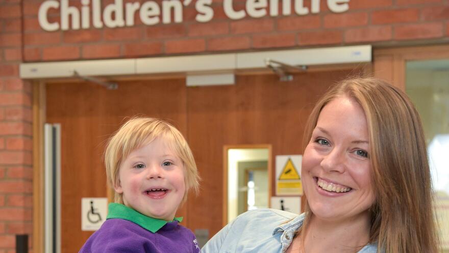Woman holding small boy with blonde hair