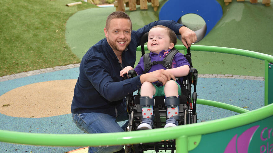 Man stood by side of child in wheelchair