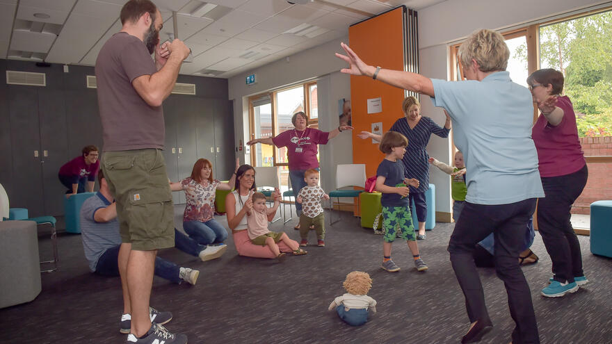 Group of adults and children taking part in music therapy session