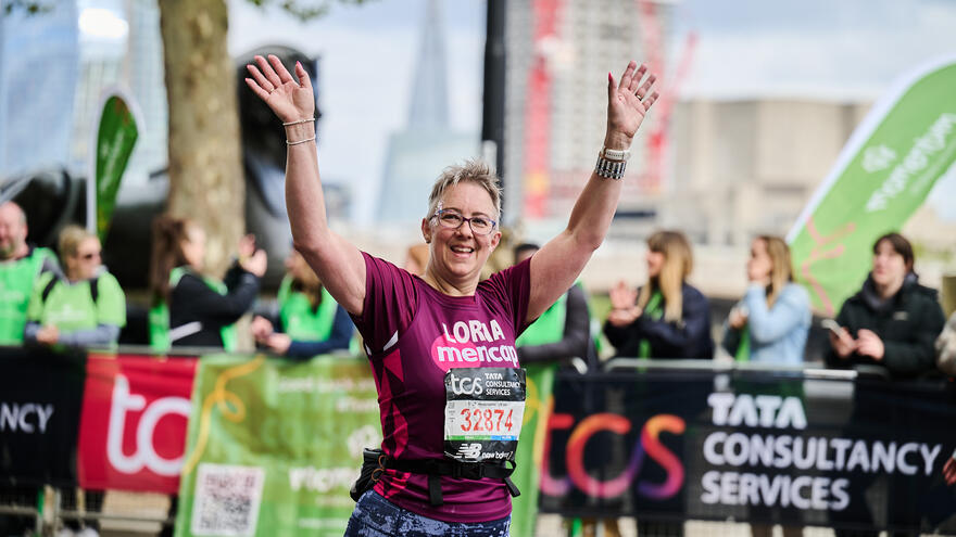 Person with arms in the air running the London Marathon