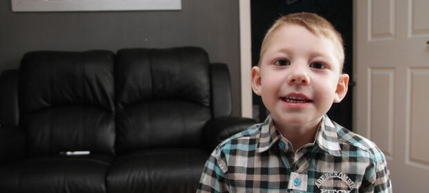 Young boy stood in front of sofa