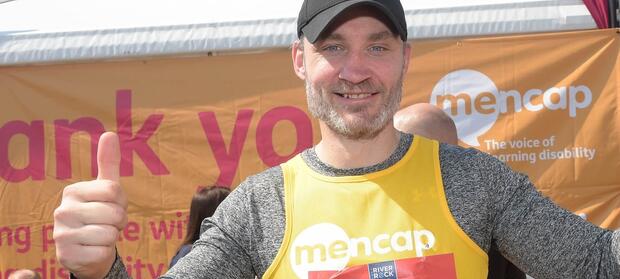 Man smiling a giving the thumbs up sign with his hand