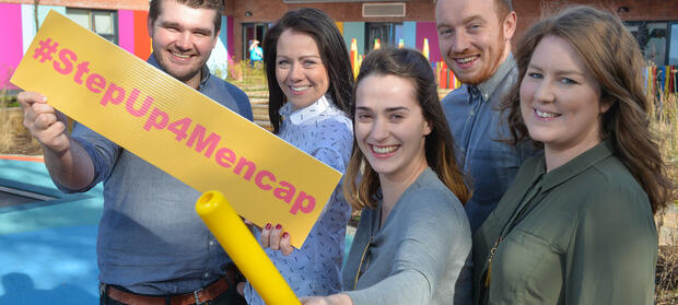 Group of people stood outside Mencap Centre in Belfast holding a #StepUp4Mencap banner