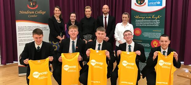 Group of people in Nendrum College holding yellow Mencap running vests