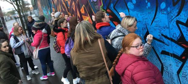 Group of people from HEROES Youth Project stoof at Belfast Peace Wall