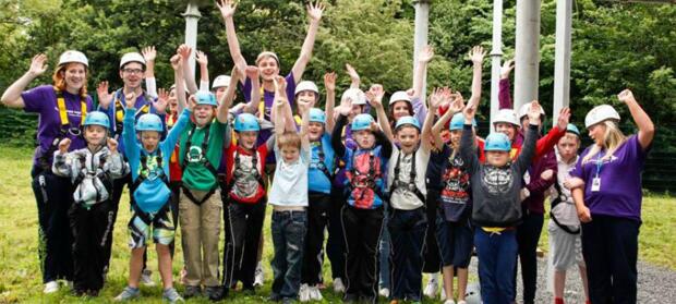 Group of children stood in park wearing hard hats