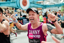 A male runner cheering in the crowds